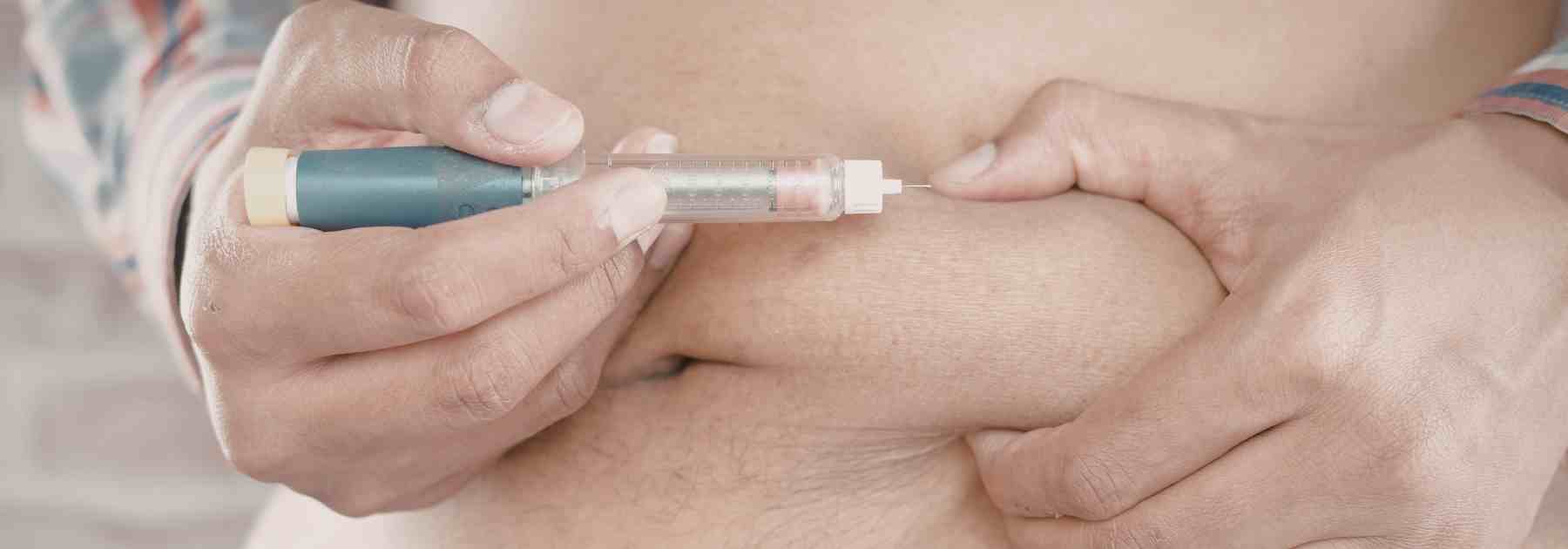 Injecting Mounjaro weight loss medication into stomach