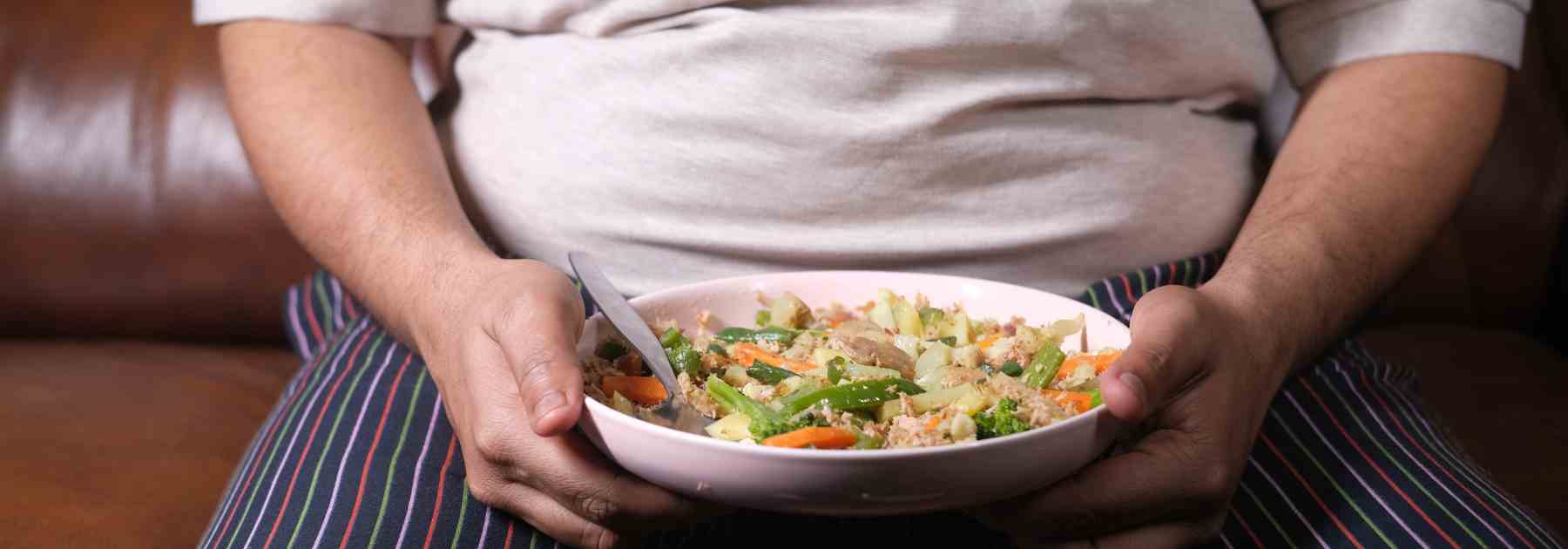 Obese man with a healthy plate of food to help weight loss